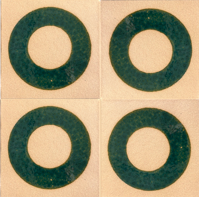 Four green glazed tile circles in pattern on a beige background